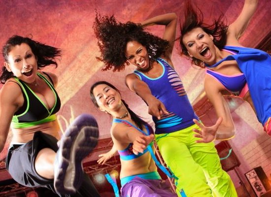 young women in sport dress jumping at an aerobic and zumba exercise